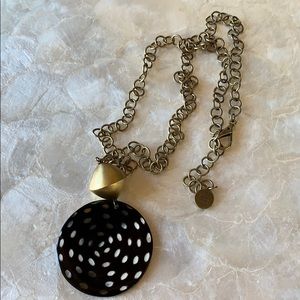 NEST Bow necklace. Metal has a brassy finish.